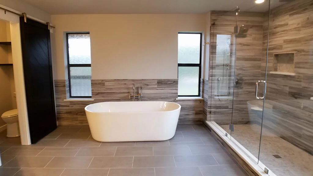 8 foot shower with a large freestanding bathtub and a custom barn door