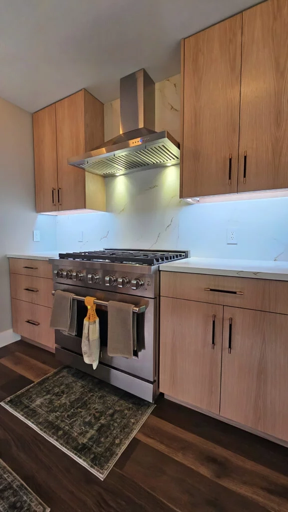 Kitchen with a 36-inch ZLINE range, engineered-quartz countertops, matching backsplash, and rift-cut white oak cabinets.