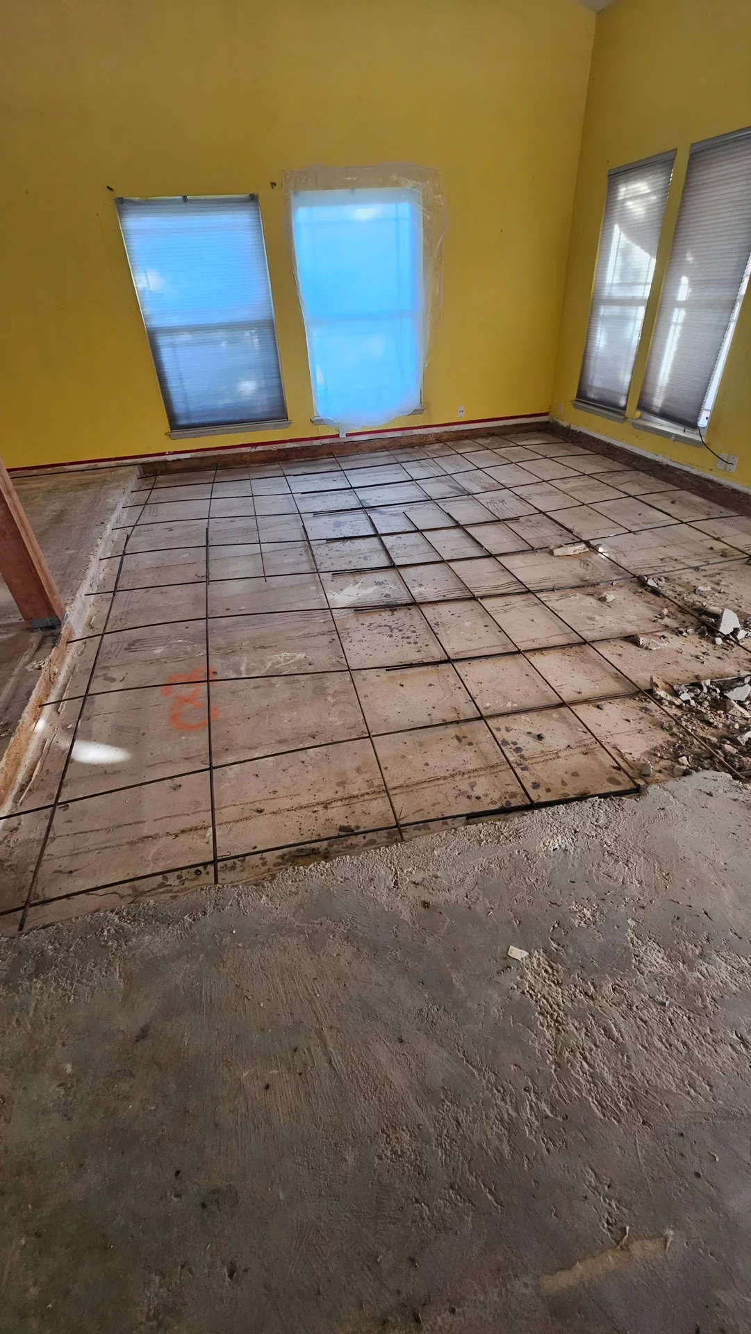 Sunken living room floor being filled with concrete to raise it to the level of the surrounding rooms.